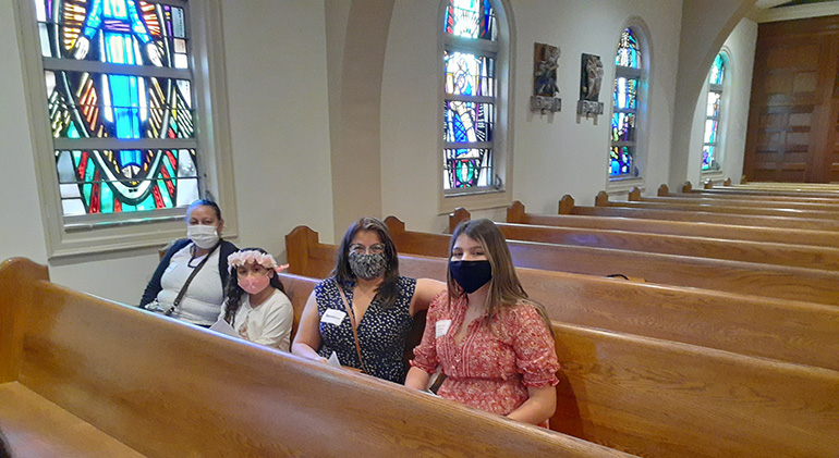 Nancy Mowa (extrema izquierda) y su nieta Isabella Vasallo, quien participa en el programa Rito de Iniciación Cristiana para Adultos (RICA) de la parroquia St. Joseph, esperan que comience la ceremonia del Rito de Elección en la Catedral St. Mary, el 21 de febrero 2021. Están sentadas con Agustina Morales, en la extrema derecha, quien también está en el programa, y su patrocinadora, Alicia García.