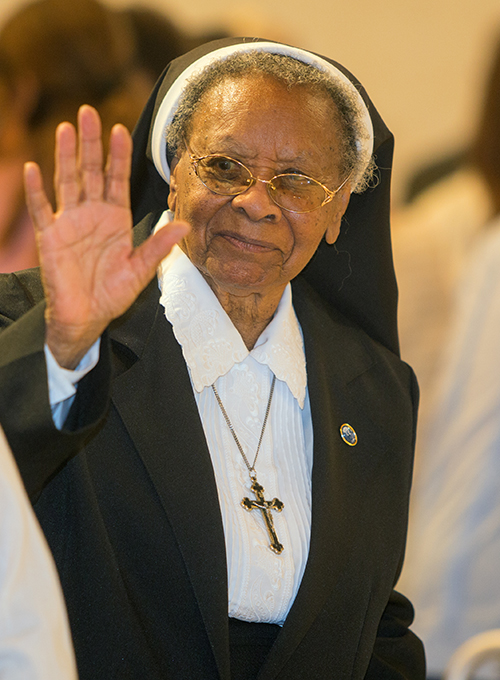 Sister Clementina Givens waves at other religious the Mass marking her diamond jubilee (75th anniversary) of religious life, celebrated at St. Patrick Church, Miami Beach, Sept. 12, 2015.