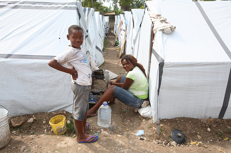 Child earthquake refugees pose for the camera at a tent city in Port-au-Prince in the file photo from March 2010. One decade later, tens of thousands are still living in tent camps.