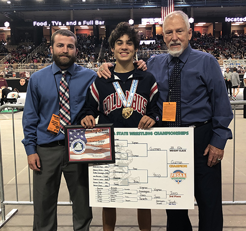 Columbus state wrestling champion Christian Guzman is pictured here with wrestling coaches Jacob Grant, left, and head varsity wrestling coach Jim Husk, right.