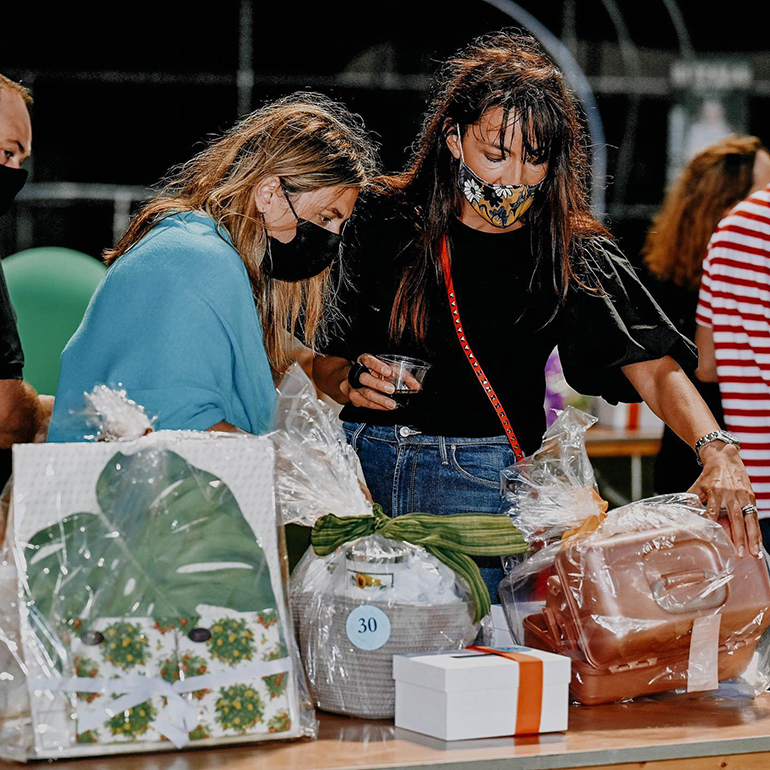 Participants look over the baskets they will "bid" on during Immaculata-La Salle High School's Tricky Tray fundraising event March 18, 2021. Funds will go toward a new athletic field and fine arts building at the Miami high school.