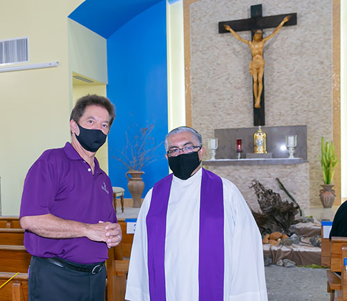 Peter Routsis-Arroyo, CEO of Catholic Charities, speaks to Msgr. Roberto Garza, pastor at St. Joachim Church and chair of the agency's board of directors, before the start of the Mass marking Catholic Charities' 90th anniversary, March 26, 2021.