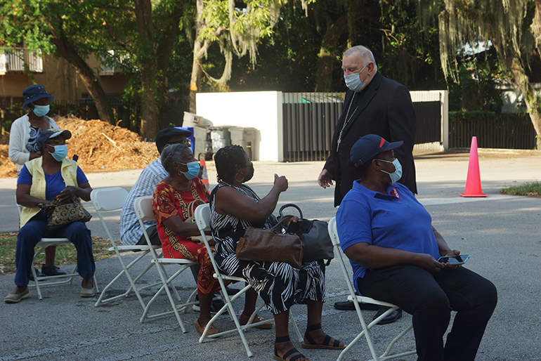 Archbishop Thomas Wenski speaks to people waiting to get vaccinated against COVID-19 at Notre Dame d'Haiti Mission in Miami on April 14, 2021. He recently put out a video in Creole urging the Haitian community to get vaccinated.