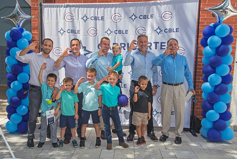 Throwing up the "C" for Christopher Columbus High School, from left: Brian Carricarte, Andrew Carricarte, Louie Carricarte, Michael Carricarte, Jr., Michael Carricarte, Sr. and their male children, future Columbus students. The Carricarte family gave their name and support to Columbus' business career pathway, now named the Carricarte Business, Leadership and Entrepreneurship program, at a ceremony held April 15, 2021 at the all-boys Miami high school.