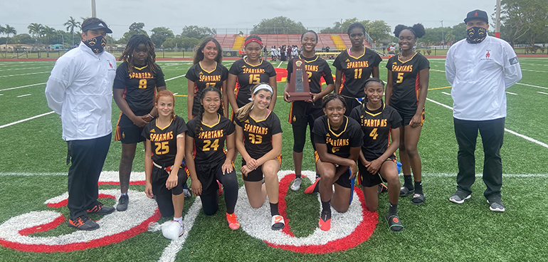 Members of Msgr. Edward Pace High School's girls flag football team pose with their district championship trophy, April 20, 2021. Next stop: Regional playoffs April 28 on the Pace campus, and a shot at the state championship.