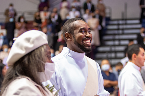 Deacon Jeremy Lully flashes a big smile at the start of the Mass. Next to him is his mother, Carmelle Lully.

Archbishop Thomas Wenski ordained eight new priests for the Archdiocese of Miami in a moving ceremony May 8, 2021. The ordination took place at St. Thomas University's Fernandez Family Center in order to accommodate the nearly 800 in attendance  while adhering to pandemic safety protocols.