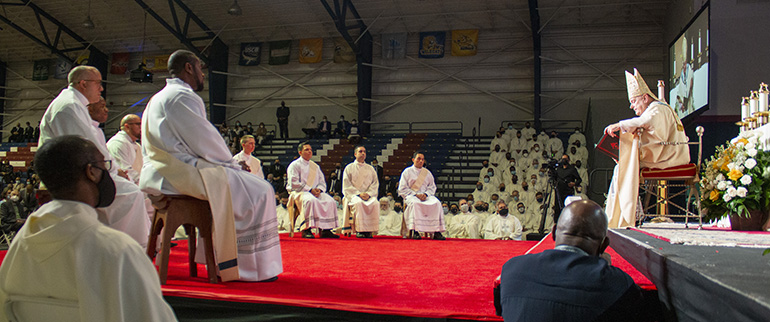 The soon-to-be-ordained priests listen to Archbishop Thomas Wenski's homily. The archbishop ordained eight new priests for the Archdiocese of Miami in a moving ceremony May 8, 2021. The ordination took place at St. Thomas University's Fernandez Family Center in order to accommodate the nearly 800 in attendance while adhering to pandemic safety protocols.