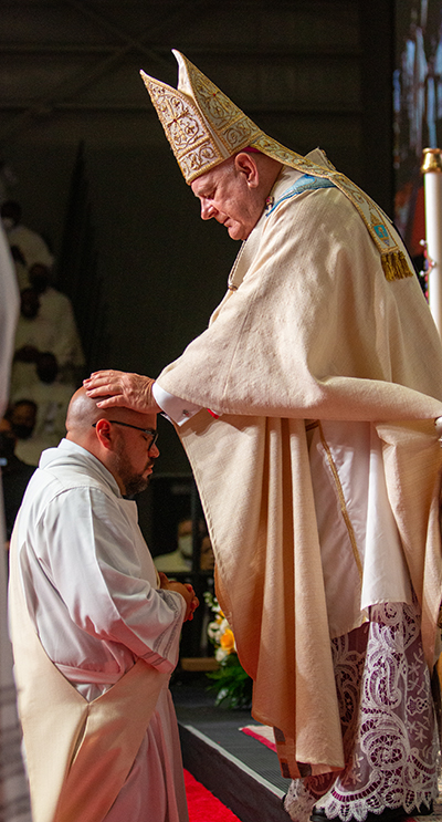 Archbishop Thomas Wenski lays hands on Deacon Alberto Chavez, ordaining him as one of eight new priests for the Archdiocese of Miami, May 8, 2021.