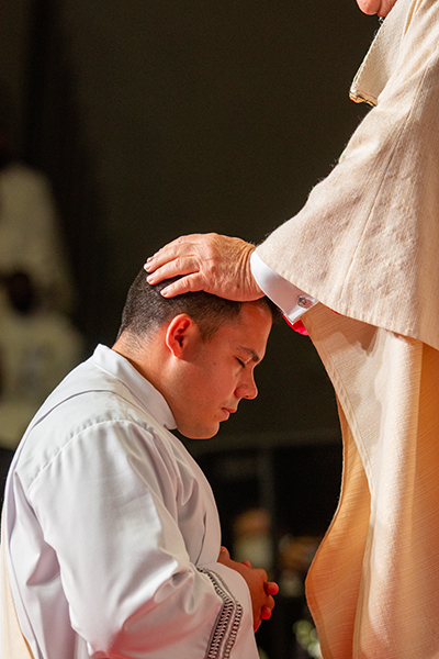 Archbishop Thomas Wenski lays hands on Deacon Nicholas Toledo, ordaining him as one of eight new priests for the Archdiocese of Miami, May 8, 2021.