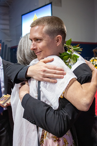 Con un lei de estilo hawaiano, el recién ordenado P. Paul Pierce abraza a su madre, Rachel Hope, después de la ceremonia.