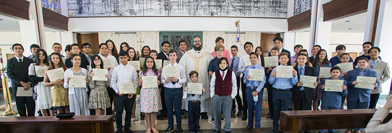 Father Matthew Gomez and the 46 altar servers who received Serra Club awards for their dedication pose for a photo in St. Raphael Chapel on the campus of St. John Vianney College Seminary. Father Gomez, Serra Club chaplain and archdiocesan vocations director, celebrated the Mass May 15, 2021.