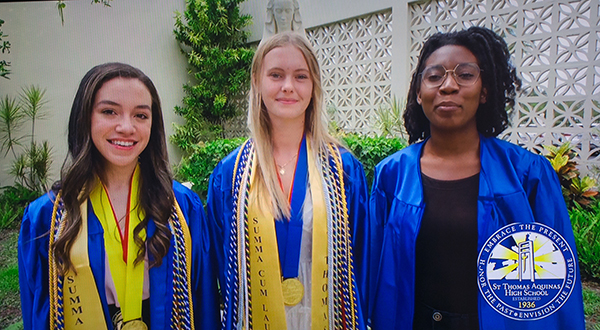 Offering greetings from their school in a loop that ran before the start of the baccalaureate Mass, from left: St. Thomas Aquinas High School's Kamila Trigueros, salutatorian, Victoria Szymkiewicz, valedictorian, and Archbishop's Leadership Award winner Kensia Saint-Hilaire. Representatives of nine of the 12 Catholic high schools in the Archdiocese of Miami took part in the Mass, celebrated by Archbishop Thomas Wenski May 24, 2021 at St. Mary Cathedral.