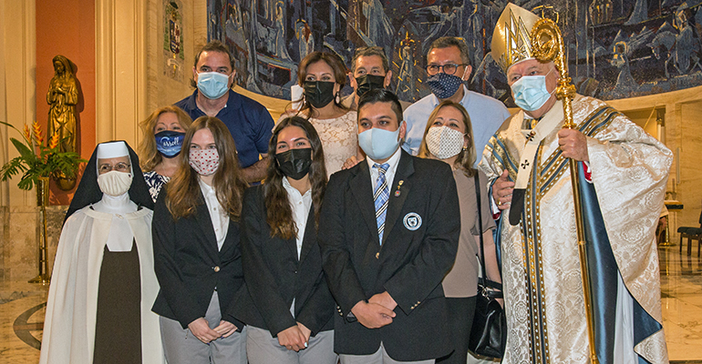 Archbishop Coleman Carroll High School's vice principal, Carmelite Sister Ines, poses with Archbishop Thomas Wenski and her school representatives after the baccalaureate Mass May 24, 2021. From left, front: Elizabeth Fitzgerald, 18, valedictorian, Camila Gloria, 18, salutatorian, and Daniel Valdez, 19, Archbishop Wenski Leadership Award winner. Behind them are their parents.