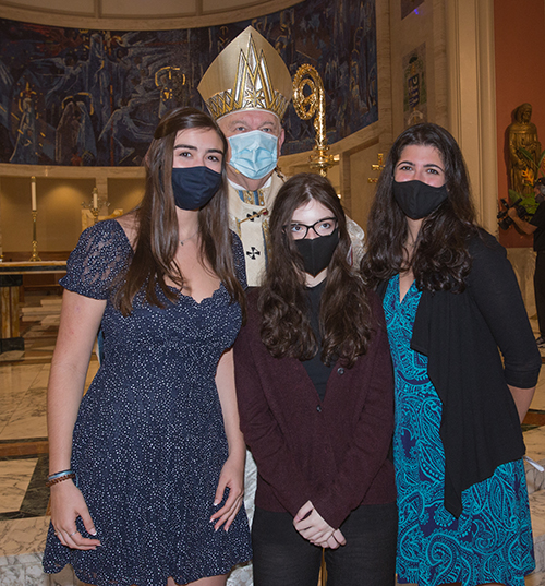 Archbishop Thomas Wenski poses for a photo with Archbishop Edward McCarthy High School's salutatorian, Cali Hinesley,17, left, valedictorian Adriana Garcia, 17, center, and Maria Soto, 18, Archbishop's Catholic Leadership Award recipient, after the baccalaureate Mass, celebrated May 24, 2021 at St. Mary Cathedral.