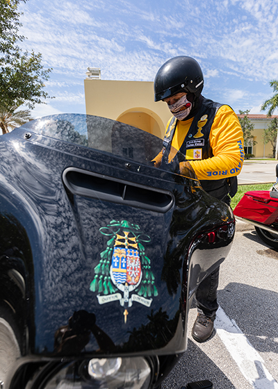 Archbishop Thomas Wenski checks his personal motorcycle before going on the road with more than 20 participants from around Florida during the first Knights of Columbus-affiliated Ride for Vocations. Conducted in conjunction with the Knights on Bikes organization of Florida, the event took place May 27, 2021 starting at St. Katharine Drexel Church in Weston.