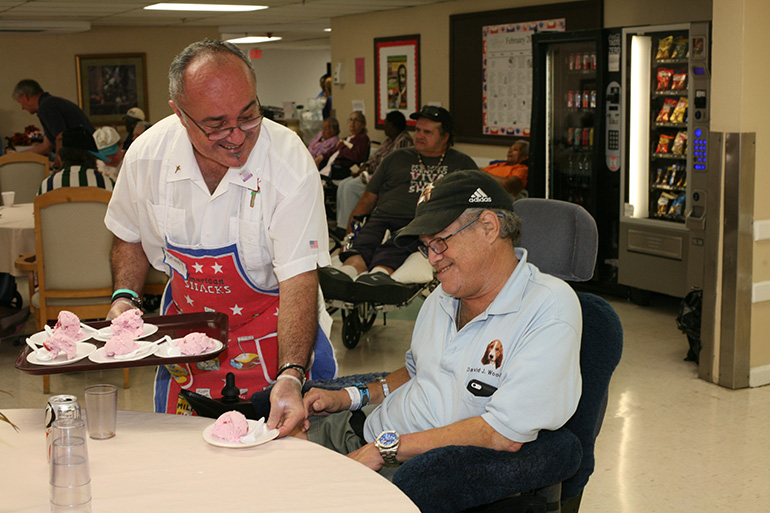 In this file photo from 2014, Vinnie Pisciotta serves ice cream to Watercrest resident David Woodruff during a visit by the Emmaus Brothers of St. Rose of Lima Parish to the nursing home. The National Center on Elder Abuse reports that seniors are actively involved in or contacted regularly by religious congregations more than any other demographic group. In addition, clergy, and representatives from one’s faith community are among the few, and in many cases, the only people who visit a senior’s home or care facility.