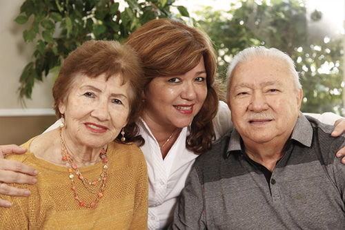 In this file photo from 2019, Jackie Pareja, Social Service Coordinator at St. Boniface Gardens, poses with her parents who are residents of the facility. Catholic Housing Management, a division of Catholic Health Services, currently operates 16 HUD subsidized apartment complexes for active, independent seniors with limited financial resources in Miami-Dade and Broward counties.