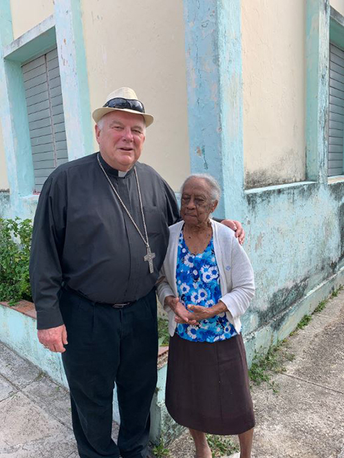 Archbishop Thomas Wenski greets a 103-year-old woman during a visit to a nursing home run by the Catholic Church next to the church of San Francisco de Paula in La Víbora, a neighborhood on the outskirts of Havana, May 27, 2019.