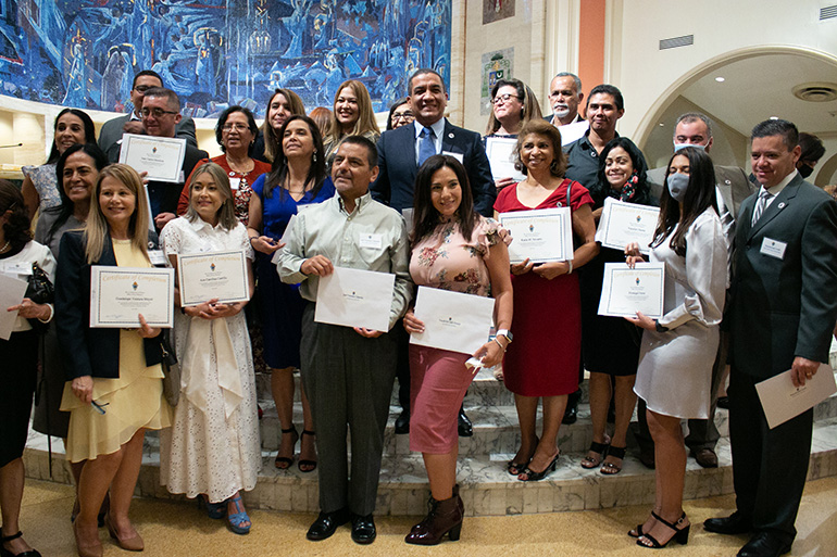 Miembros de la clase 2021 de Ministerios Laicos en español, que asistieron a sus clases en la parroquia St. Brendan, posan para una foto después de la Misa de graduación.