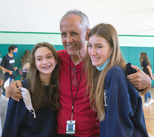 Art Fernandez poses for a photo with seventh graders Olivia Peacock and Sofia Lisamore after receiving the Key to the City of Miami Beach from Mayor Dan Gelber. Fernandez is retiring after 39 years as physical education teacher at St. Patrick School on Miami Beach.