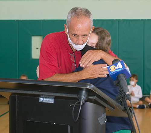 Art Fernandez hugs seventh-grader Olivia Peacock, 12,  after receiving the Key to the City of Miami Beach from Mayor Dan Gelber. Fernandez is retiring after 39 years as physical education teacher at St. Patrick School on Miami Beach.