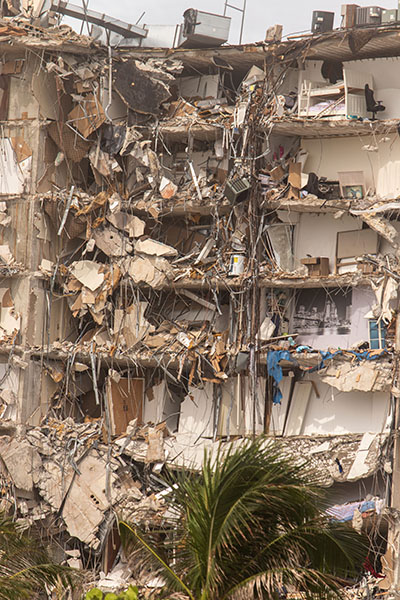 El derrumbe parcial de las Champlain Towers South, en Surfside, es visible desde la Avenida Collins, que está parcialmente cerrada a los peatones, el 25 de junio de 2021.