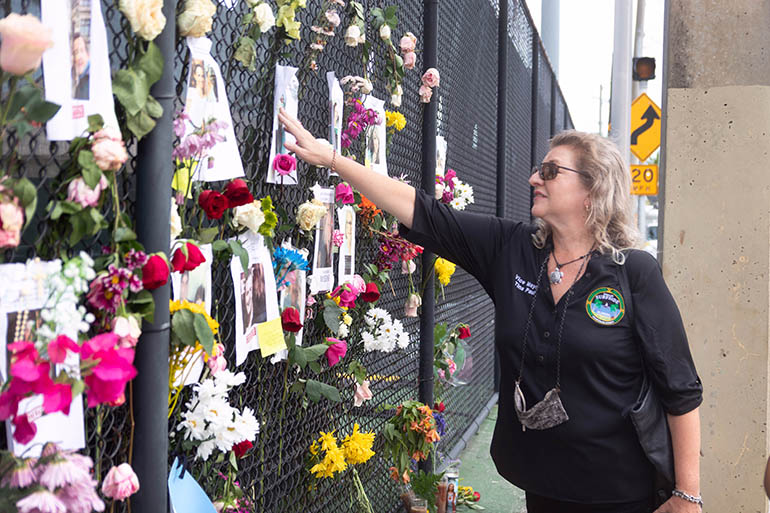 Tina Paul, vice mayor of the Town of Surfside, spends a few moments at an informal 'wall of remembrance' memorial that was created on a fence just a few blocks south of the fallen south tower at the Champlain condominium in Surfside which tragically collapsed early in the morning of June 24, 2021.