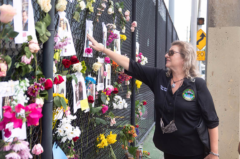 Tina Paul, vicealcaldesa de la ciudad de Surfside, pasa unos momentos en el "muro del recuerdo" informal que se creó en una valla, a poca distancia del condominio Champlain Towers South en Surfside, que se derrumbó trágicamente en la madrugada del 24 de junio de 2021.