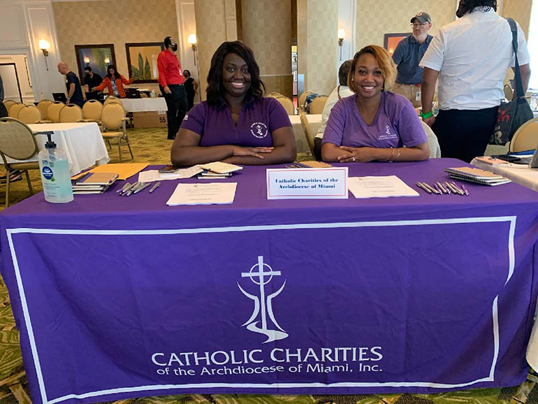 Waldine Joseph and Malena Castillo of Catholic Charities man the agency's table at the Family Assistance Center, set up at the Sea View Hotel, 9909 Collins Ave., Bal Harbour, for relatives of those missing after the collapse of Champlain Towers South in Surfside.