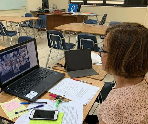 Rose Cabrera, profesora de lenguaje y religión de octavo grado de la escuela Our Lady of the Lakes, dirige la clase con estudiantes que la atienden vía Zoom. Al comienzo del año escolar 2020-2021, no era posible realizar clases presenciales. Cuando fue posible, los profesores enseñaban simultáneamente por ambas alternativas: clases virtuales y clases presenciales.