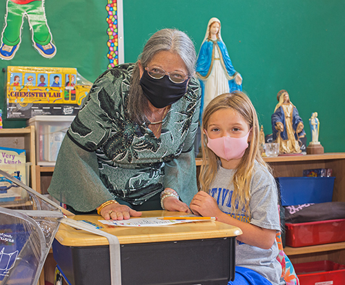 Nativity School kindergarten teacher Margaret Knowles, seen here with student Madeleine Carvajal, 6, is retiring this month, having never missed a day of teaching in 27 years.