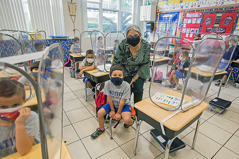 Nativity School kindergarten teacher Margaret Knowles poses with student, James Sayfie, 6, and his classmates before her last day of school. She is retiring this month, having never missed a day of teaching in 27 years.