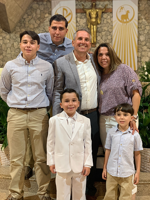 Ricardo Franco joins his family at the altar after Mass at St. David Church in Davie May 15, 2021. He is shown with his wife Olga at his side. His son Gianluca, 8, a student at St. David School, is shown in white. He received his first holy Communion during the Mass.