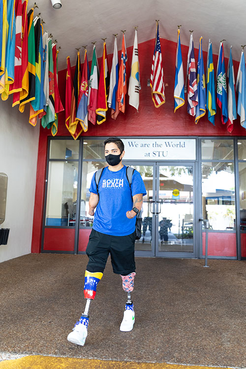 St. Thomas University student Franklin Mejias Castellano, who was left handicapped by an infection acquired during a trip to Florida from his native Venezuela when he was 12, walks through the university campus in May 2021.