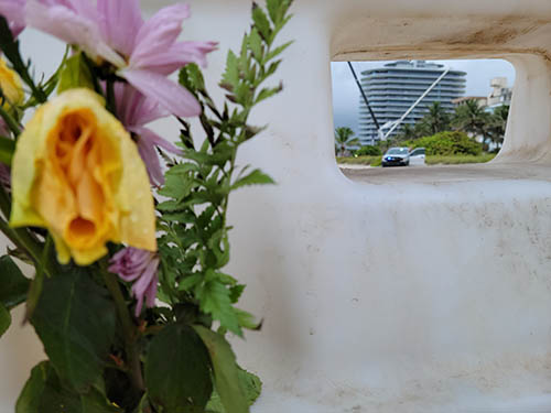 Flowers from a vigil memorial were left at the perimeter barrier set up on the beach north of the Champlain Towers South building collapse.