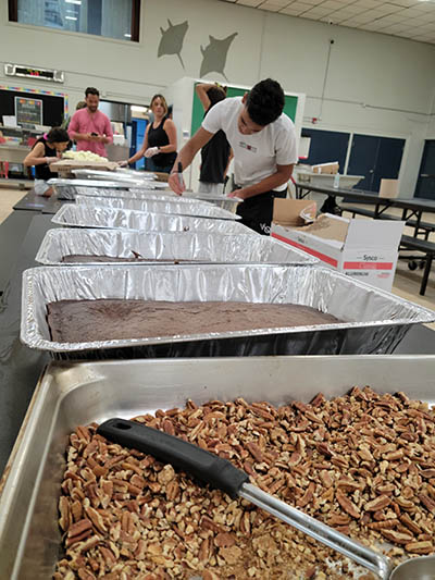 Mercy Chefs volunteers label pans of brownies for first responders and others working on site at the Champlain Towers South building collapse. Mercy Chefs is a faith-based nonprofit disaster relief organization. They are cooking at St. Joseph Church’s parish center, Minnotte Hall.