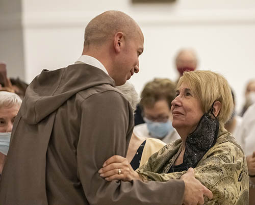 El P. Joseph Mary, recién profesado Siervo de los Corazones Traspasados de Jesús y María, abraza a su madre Judy Rogers, durante la Misa de su profesión de primeros votos religiosos, el 29 de junio de 2021, en la iglesia Our Lady of Guadalupe en Doral.