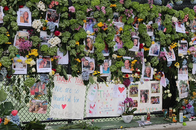 Photographs of those missing, most of them now confirmed killed in the Surfside condo collapse, fill the memorial wall erected on a tennis court fence nearby.