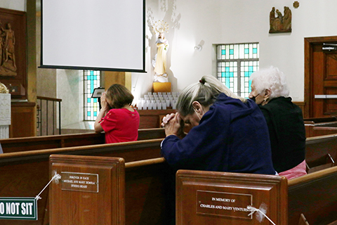 Asistentes a la Misa del miércoles, 30 de junio, en la parroquia St. Joseph, muy cerca del edificio colapsado en Surfside oran por los afectados y sus familias.