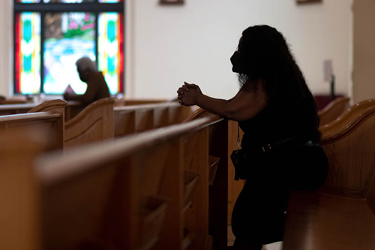 A woman prays at Notre Dame d'Haiti Mission in Miami during a eucharistic adoration and afternoon prayer vigil for Haiti held on July 7, 2021 in light of the assassination earlier in the day of Haiti's embattled President Jovenel Moisé. The community also prayed for Haiti's First Lady, who was injured in the attack and flown to Miami for medical care.