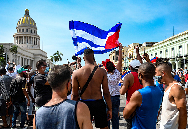 Cubans are seen outside Havana's Capitol during a demonstration against the government of Cuban President Miguel Diaz-Canel in Havana, on July 11, 2021. Thousands of Cubans took part in rare protests Sunday against the communist government, marching through a town chanting "Down with the dictatorship" and "We want liberty." (YAMIL LAGE / AFP via Getty Images)