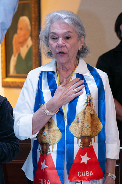 Conchita Gutierrez of Little Flower Parish in Coral Gables sings the Cuban national anthem at the start of a Mass for Cuba celebrated by Archbishop Thomas Wenski at the Shrine of Our Lady of Charity on on July 13, 2021, two days after anti-government protests broke out all over the island.