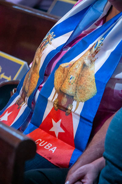 A woman wears a scarf with the image of Our Lady of Charity and the colors of the Cuban flag during a Mass for Cuba celebrated by Archbishop Thomas Wenski at the Shrine of Our Lady of Charity on July 13, 2021, two days after anti-government protests broke out all over the island.