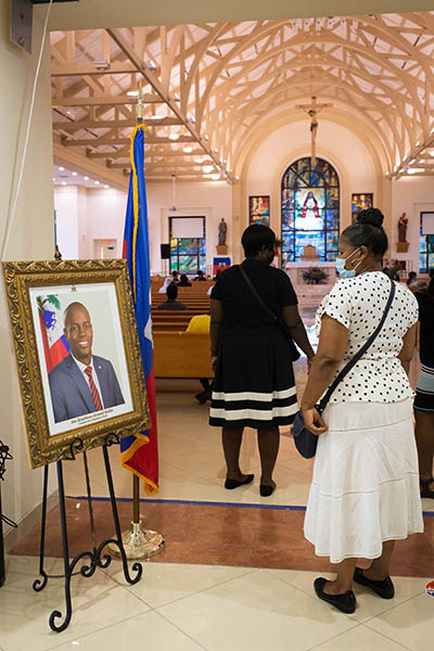 Una feligresa de la iglesia católica Notre Dame d'Haiti en Miami rinde homenaje a un retrato de Jovenel Moise el 22 de junio de 2021, durante un servicio conmemorativo allí un día antes de que el difunto presidente de Haití recibiera un funeral de estado tras su asesinato el 7 de julio. El presidente Moise fue enterrado el 23 de julio por su esposa y tres hijos en su ciudad natal de Cap-Haitien, Haití.