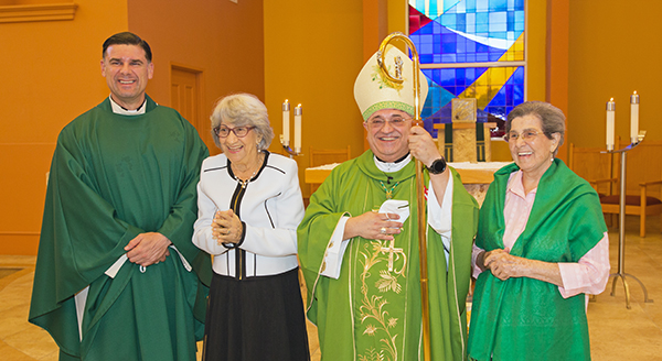 El padre Rafael Capo, vicepresidente de Misión y Ministerio de la universidad de St. Thomas, se retrata con Sofía Ruiz, el obispo auxiliar de Miami, Mons. Enrique Delgado, y Reina Marmolejos después de la misa del 25 de julio de 2021, con motivo del primer Día Mundial de los Abuelos y los Ancianos. El Obispo Delgado celebró la Misa en la capilla de St. Anthony de la universidad.