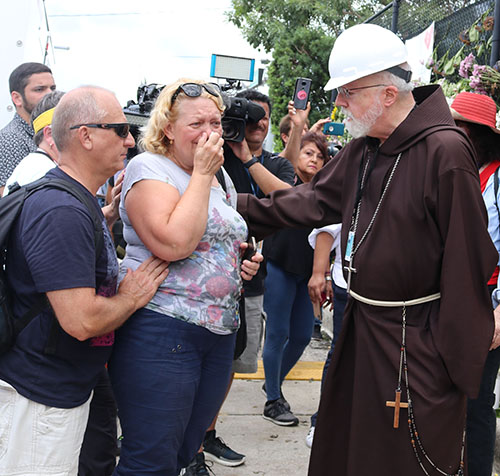 El Cardenal Sean Patrick O’Malley, Arzobispo de Boston, habla con la madre de Anastacia Gramova, desaparecida en el colapso del edificio de apartamentos Champlain Towers South, en Surfside, el 24 de junio. El Cardenal O’Malley visitó la zona del derrumbe con el Arzobispo Thomas Wenski el 2 de julio de 2021.