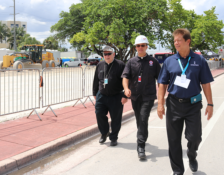 El Arzobispo Thomas Wenski camina con Peter Routsis-Arroyo, director ejecutivo de Catholic Charities (derecha), y el P. Christopher Marino (centro), rector de la Catedral de St. Mary y capellán del Cuerpo de Bomberos de la Ciudad de Miami después de visitar el sitio del derrumbe de Champlain Towers South, el 2 de julio.