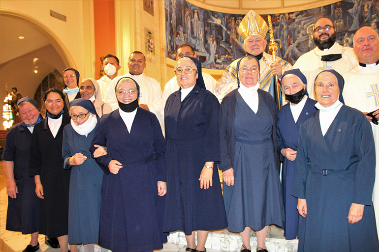 Las Hijas de la Caridad de San Vicente de Paúl, el Arzobispo Thomas Wenski y sacerdotes arquidiocesanos posan para la foto en el altar de la Catedral de St. Mary después de celebrar una Misa el 14 de agosto de 2021, por los 50 años de la llegada de las hermanas a Miami.