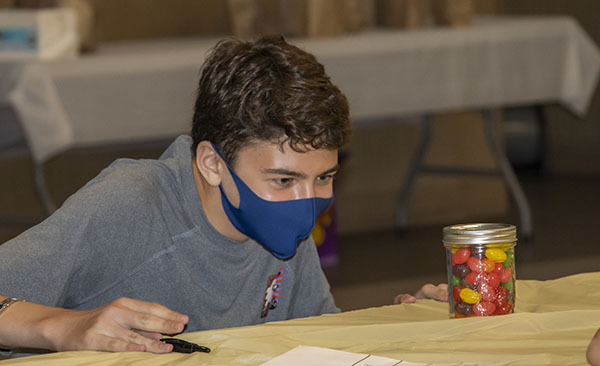 Edgar Batista from Mast Academy in Key Biscayne participates in one of the events at the Blessed Trinity Life Teen Office Olympics, Sept. 12, 2021. In this event, teams tried to guess how many jelly beans are in a jar. The team who made the closest guess, won.