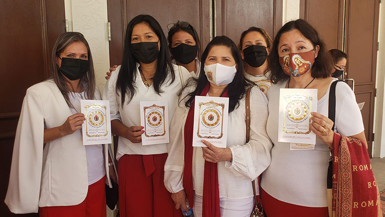 Feligreses de la parroquia de San Isidro en Pompano Beach muestran los certificados que representan su membresía en la Guardia de Honor del Sagrado Corazón. Se hicieron miembros de la asociación durante la misa del 11 de junio de 2021, fiesta del Sagrado Corazón.